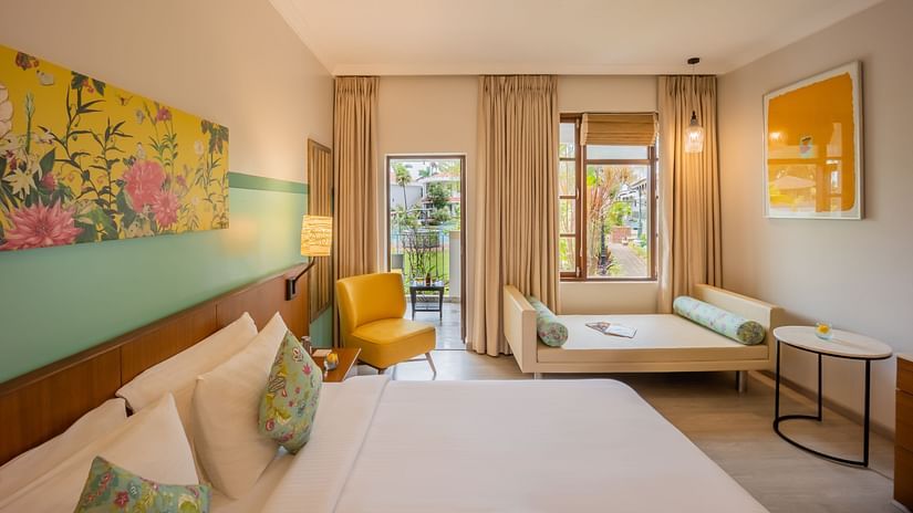 room with a king size bed and vibrant yellow interiors at Heritage Village Resorts and spa