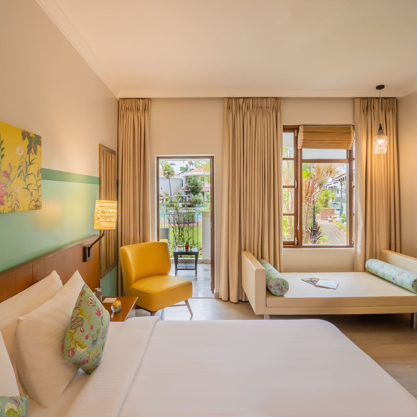 room with a king size bed and vibrant yellow interiors at Heritage Village Resorts and spa
