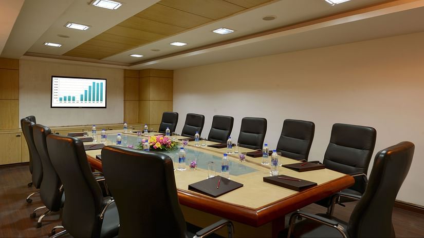 A conference room with chairs tables and a TV