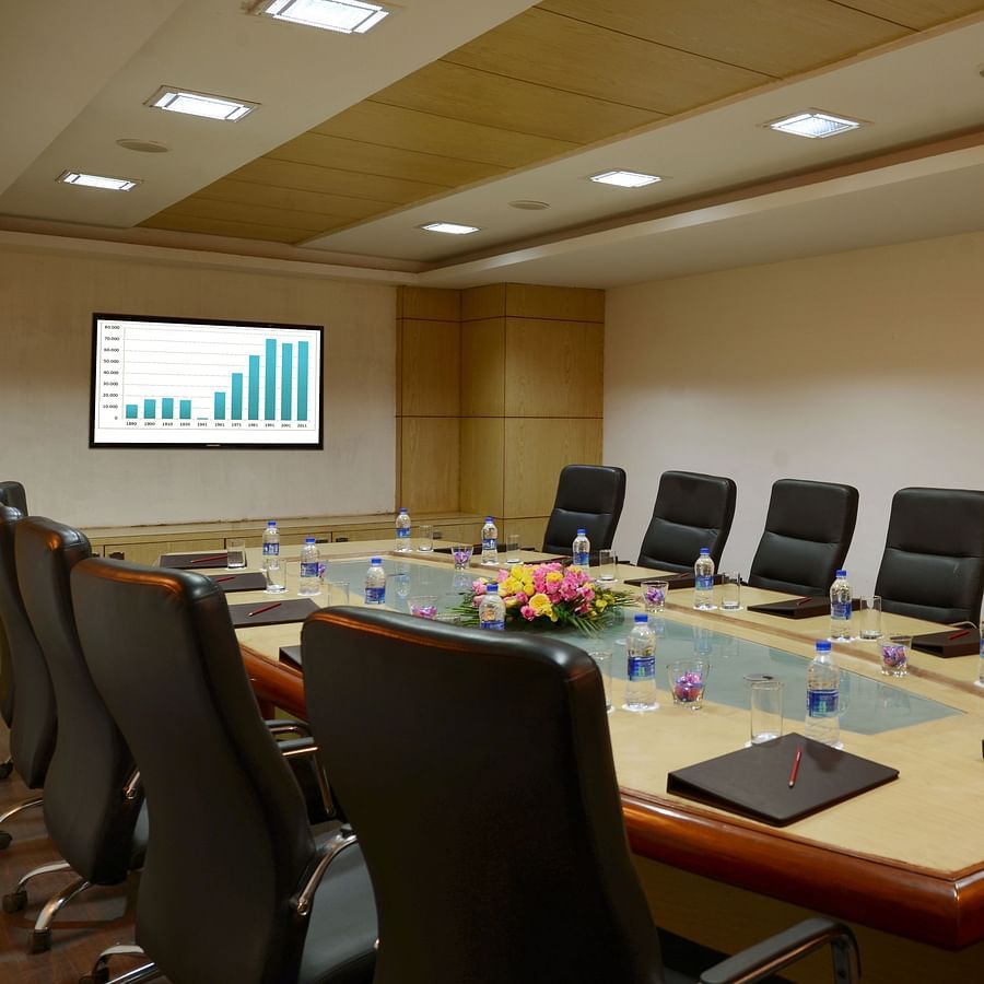 A conference room with chairs tables and a TV