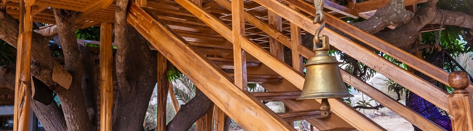Wooden stairs on a tree house and a bell