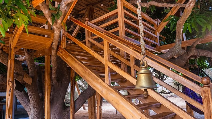 Wooden stairs on a tree house and a bell