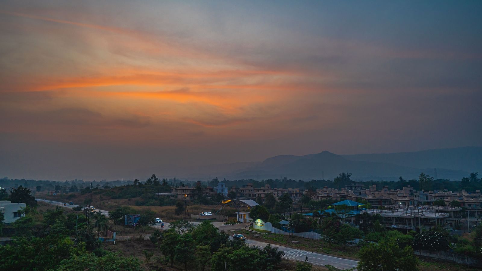 A peaceful sunset view with a soft glow over a small town and surrounding hills at Lotus Leaf Boutique Hotel.