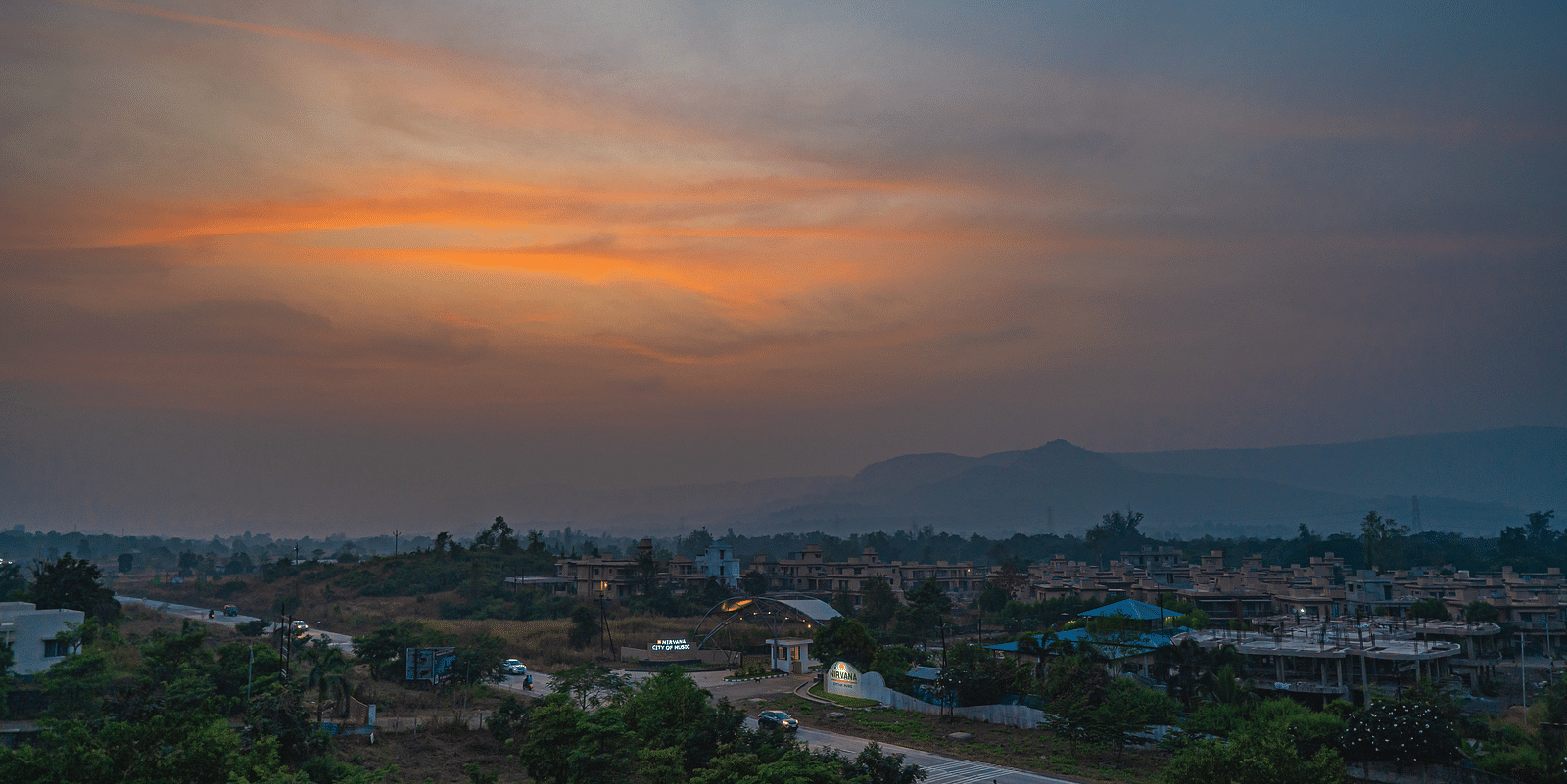 A peaceful sunset view with a soft glow over a small town and surrounding hills at Lotus Leaf Boutique Hotel.