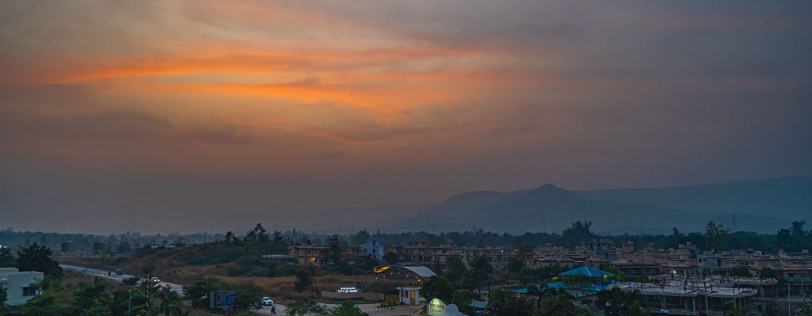 A peaceful sunset view with a soft glow over a small town and surrounding hills at Lotus Leaf Boutique Hotel.