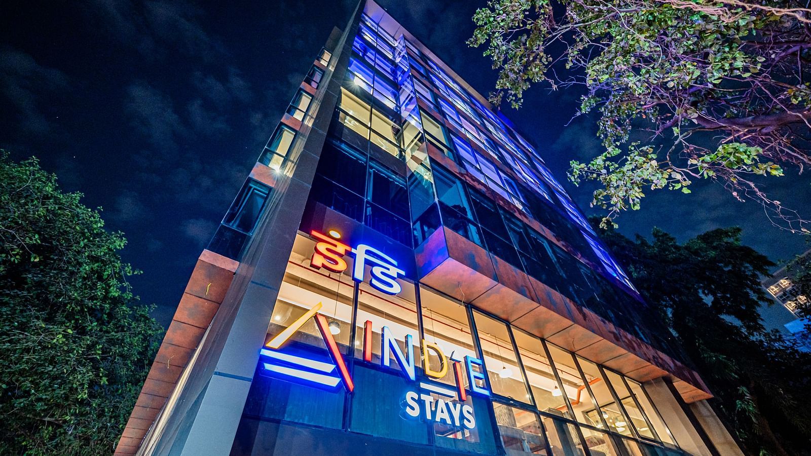 A low-angle view of Indie Stays Mumbai International Airport, towering against the night sky.