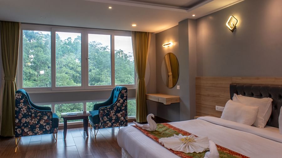 Premuim river view room with bed, seating area and large windows at  Avianna Ganagtok Resort and Spa