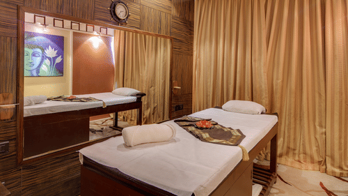 Image of a massage bed with towels on it next to a large horizontal mirror at Body Raga Spa in Chennai