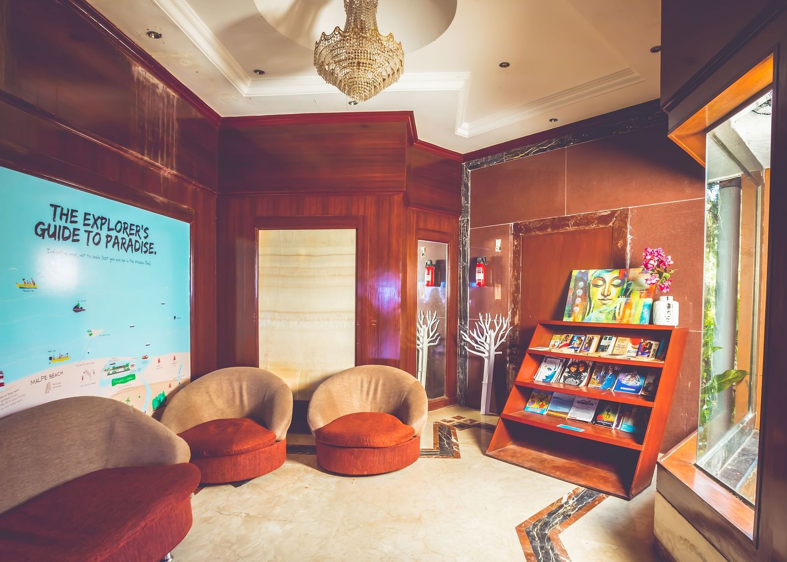 Indoor reading area with chairs and a magazine stand at Paradise Isle Beach Resort, Udupi