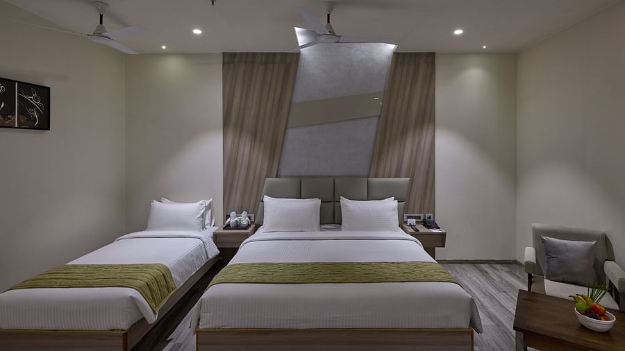 A king bed, a single bed and a sofa on the side inside family room at Grand Continent - A Sarovar Premiere Affiliate Hotel, Hosur