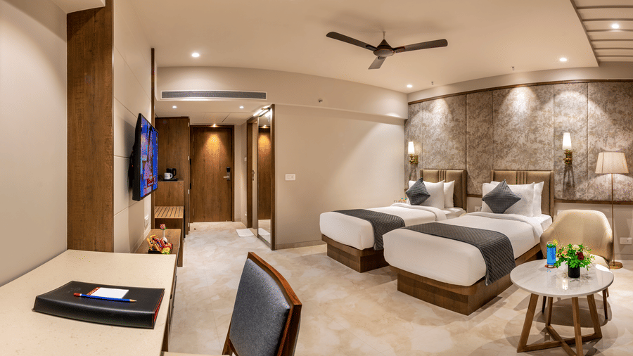 Corner view of the Executive Room featuring twin beds surrounded by modern interiors, with a work station in the corner - Skkylight Lords Inn, Nanded