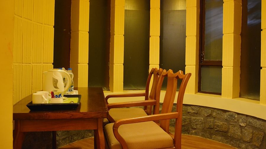 a table with two chairs placed in a room - Kadkani River Resort, Coorg