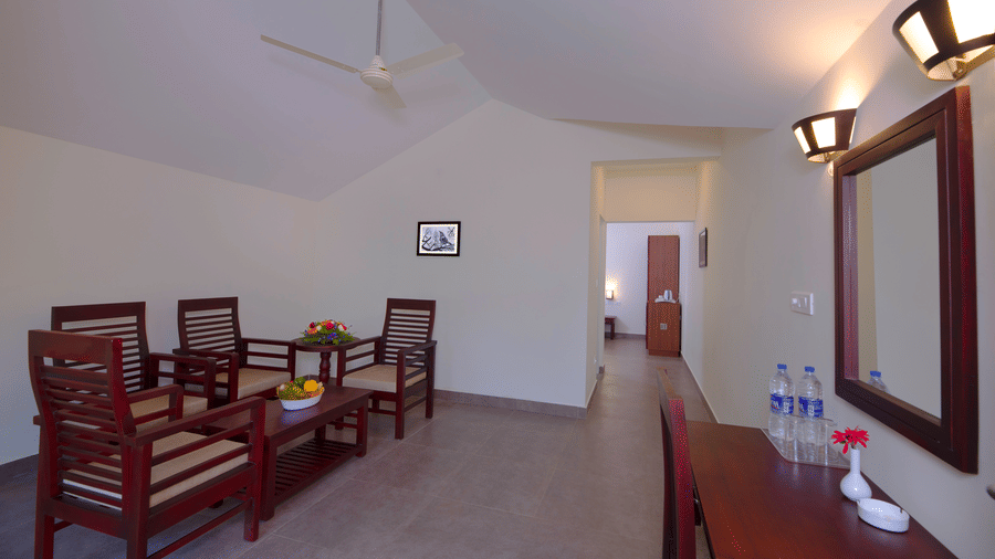 A room features a dining set, a mirror, and a hallway leading to another room.