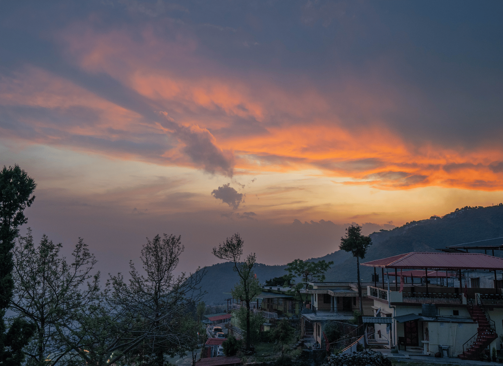 A sunset view over the hills and town from Perfectstayz Value Paradise, Mussoorie.
