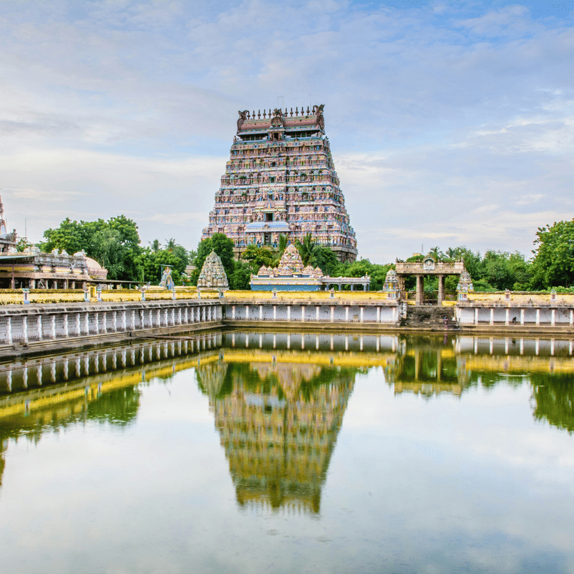 A grand South Indian temple with towering gopurams and a sacred water tank reflecting its intricate architecture.