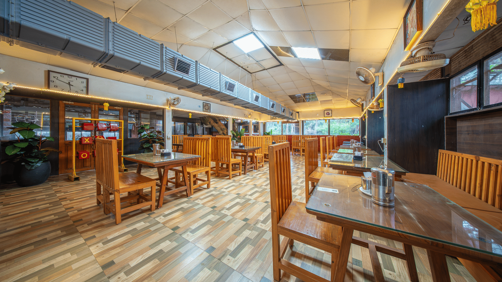 Restaurant interior with wooden tables, chairs, and wide windows at a Tranquil Group.