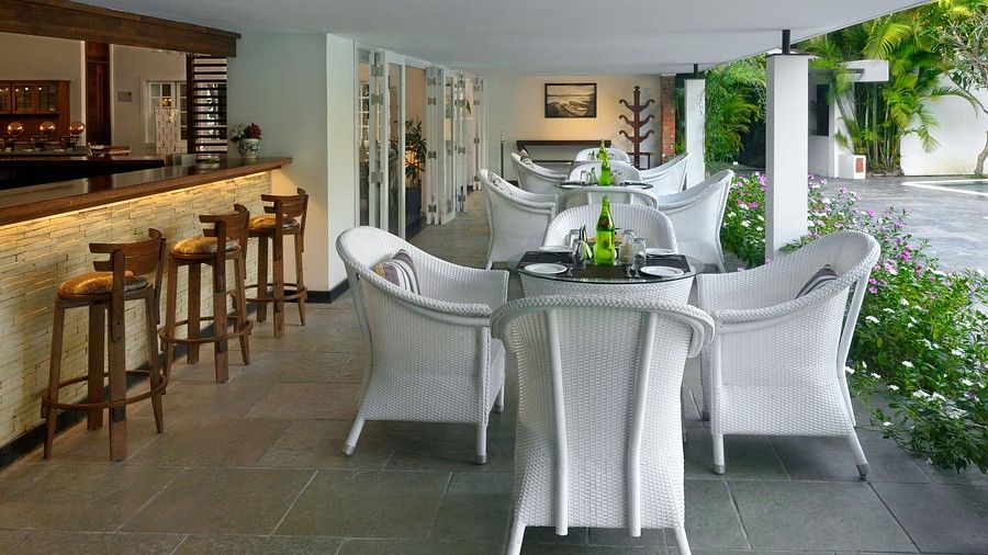 Dining  area with white colour wooden furniture and with green plants around 