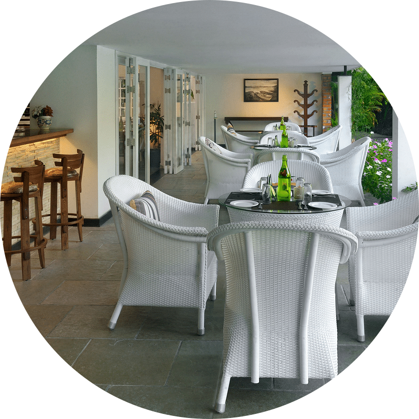 Dining  area with white colour wooden furniture and with green plants around 