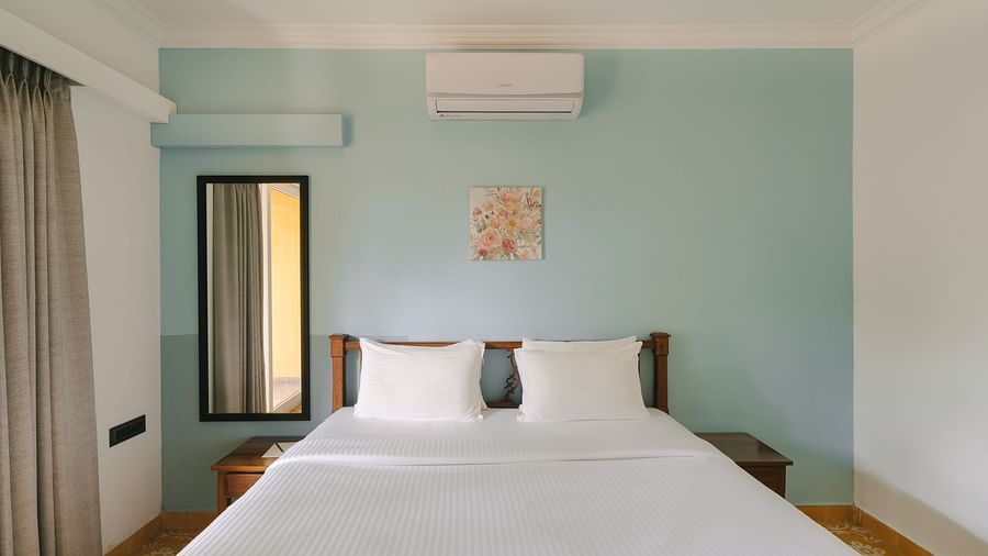 Comfortable king-size bed with pastel interiors at One BHK Apartment, Richmonde Ananta Elite, Goa.