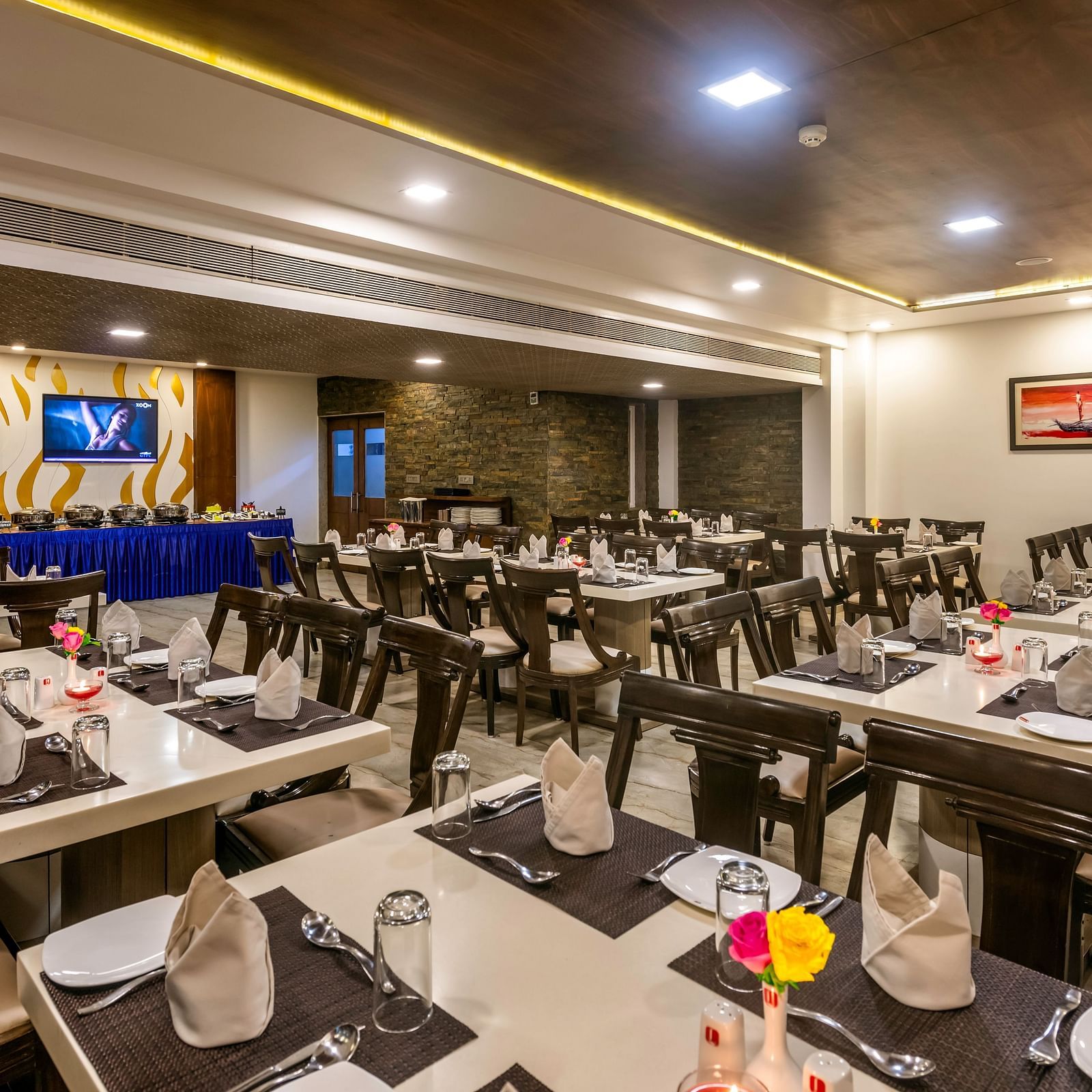 A brightly lit restaurant at Dwarkadhish Lords Eco Inn with neatly arranged tables and chairs, ready for diners.