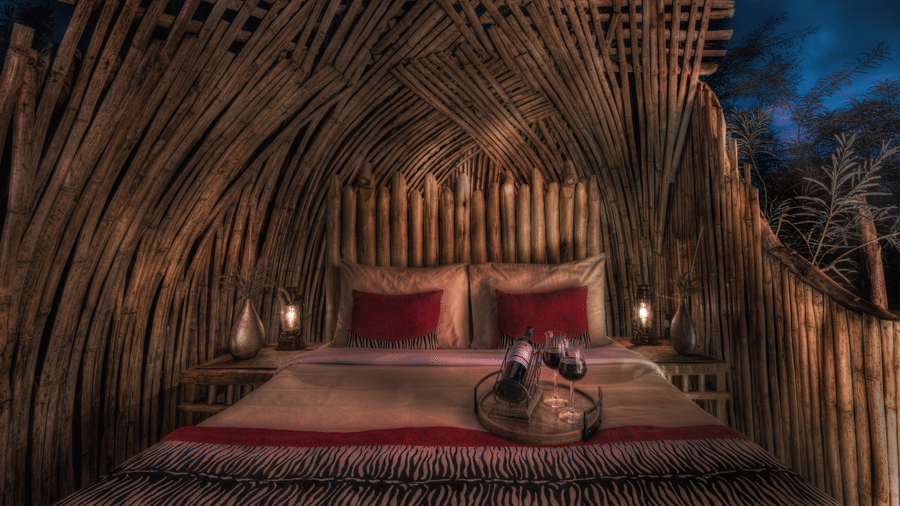 Bamboo thatched bedroom with red accent decor at Evolve Back Kabini