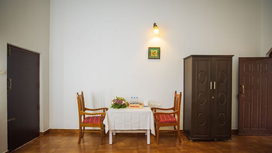 A dining section inside a room with chairs and tables for a couple - Capitol Village Resort, Madikeri