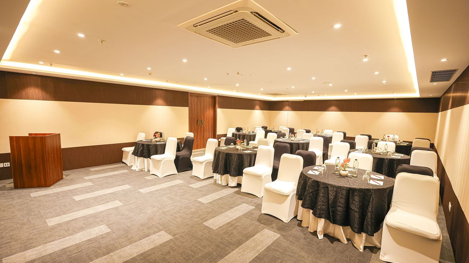 A row of white upholstered armchairs and sofas sit in the lobby of the Rhythm Gurugram, Hotel and Suites in Gurgugram. 