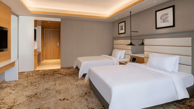 Twin Bedroom with two queen size beds and wall mounted TV.