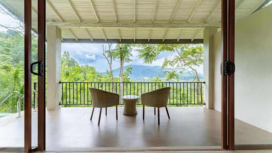 A back view of two chairs and jute stool placed in a balcony with mountain view | Celestial Hills, Kandy