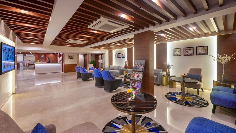 Lounge space with modern seating arrangement and stylish ceiling detailing - Lords Eco Inn Shapar Rajkot