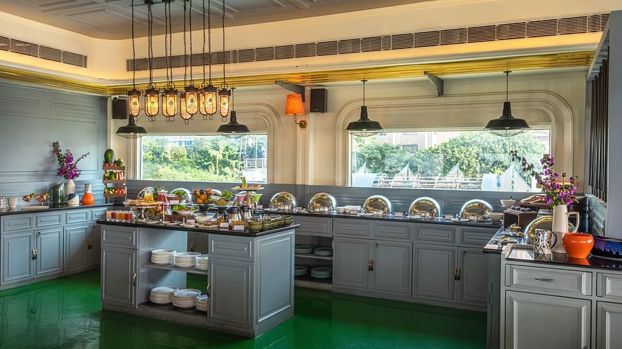 A restaurant with a spacious buffet area featuring a variety of food stations and tables set for dining.