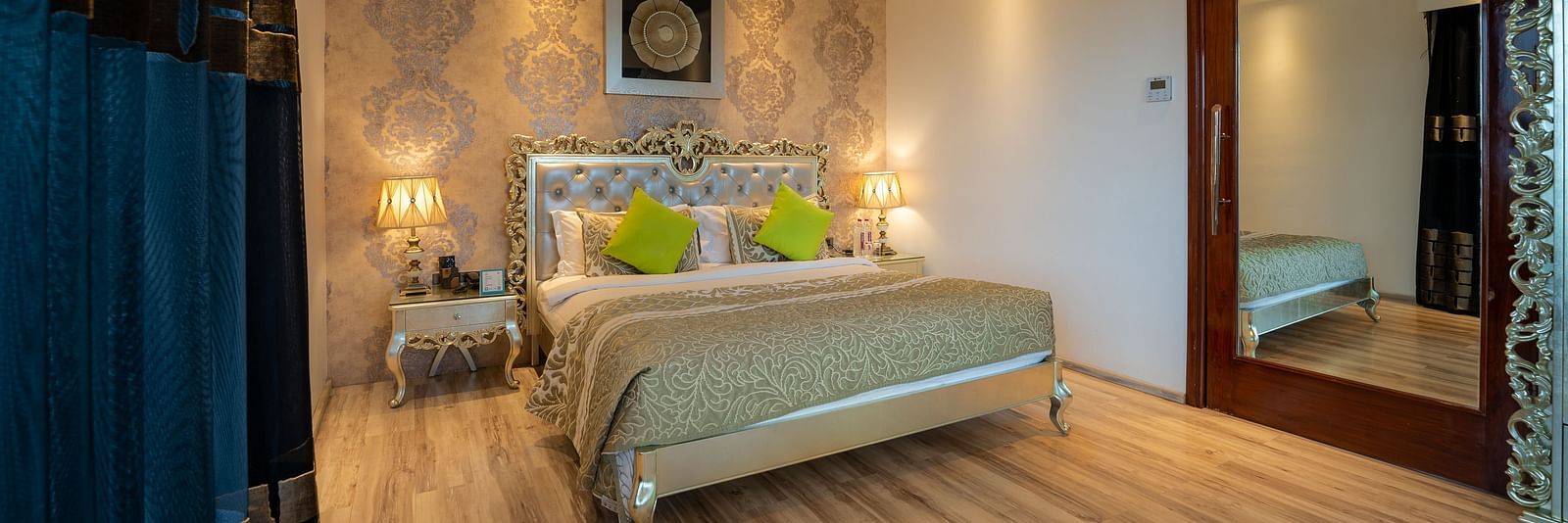 At Crescent Spa & Resort, Indore, the spacious bed features a photo frame above the headboard and is accompanied by two bedside tables illuminated with warm lighting