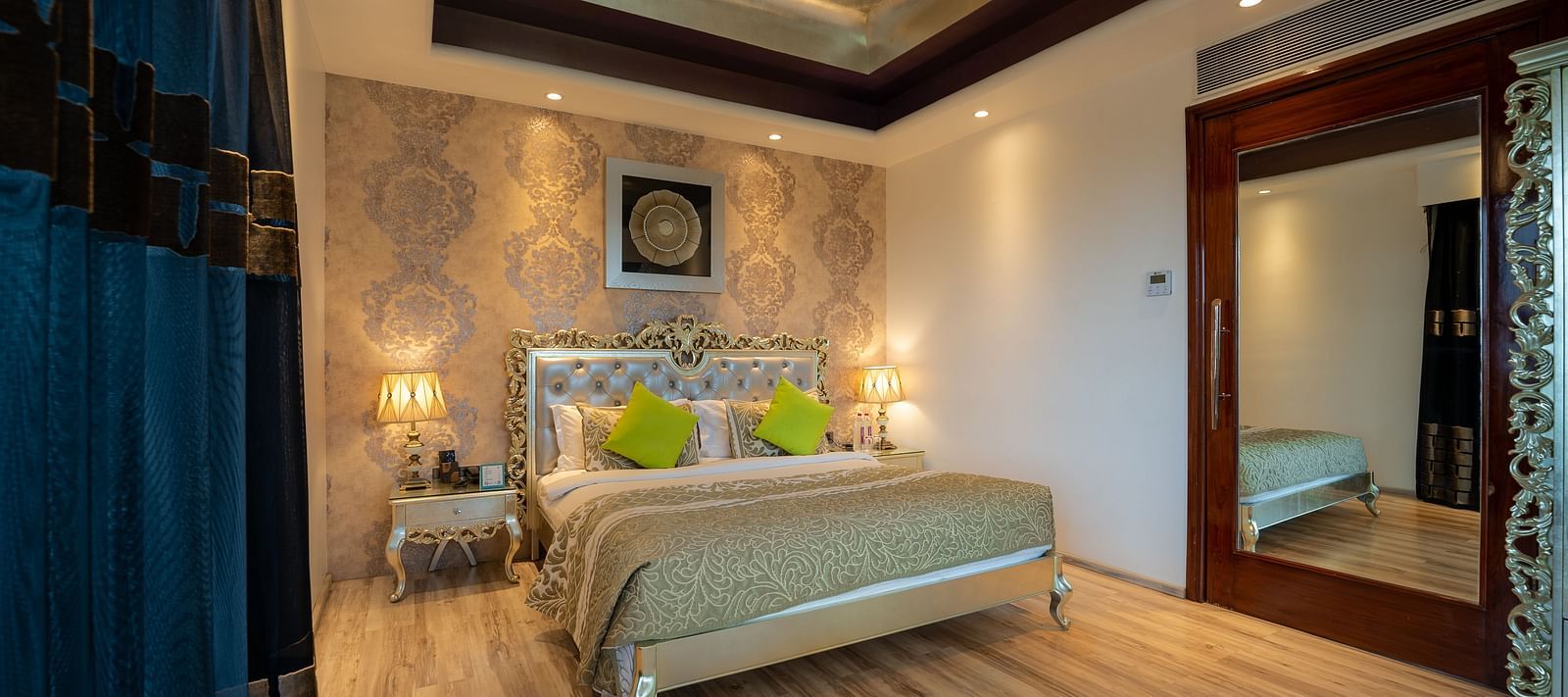 At Crescent Spa & Resort, Indore, the spacious bed features a photo frame above the headboard and is accompanied by two bedside tables illuminated with warm lighting