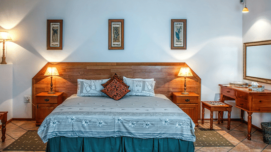 Front view shot of a bedroom featuring a double bed with bright table lamps besides the bed on both sides.
