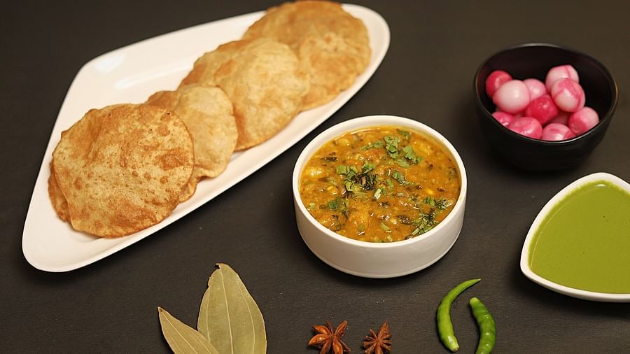 An image of chole bhature served with green sauce and onions at a restaurant in Five Elements Hotels North Avenue, Delhi