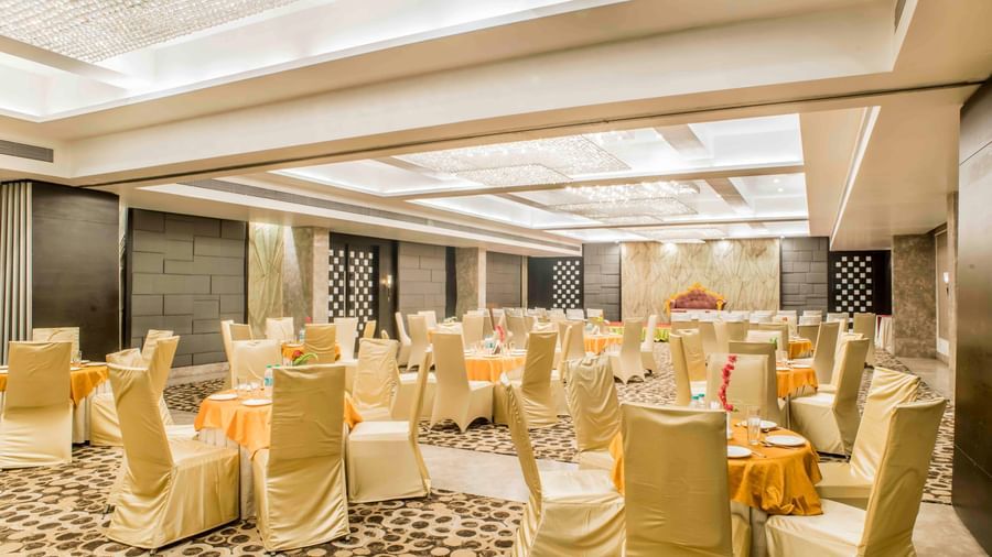 An expansive banquet hall prepared for an event with round tables and chairs at The Citi Residenci Hotel, Durgapur.