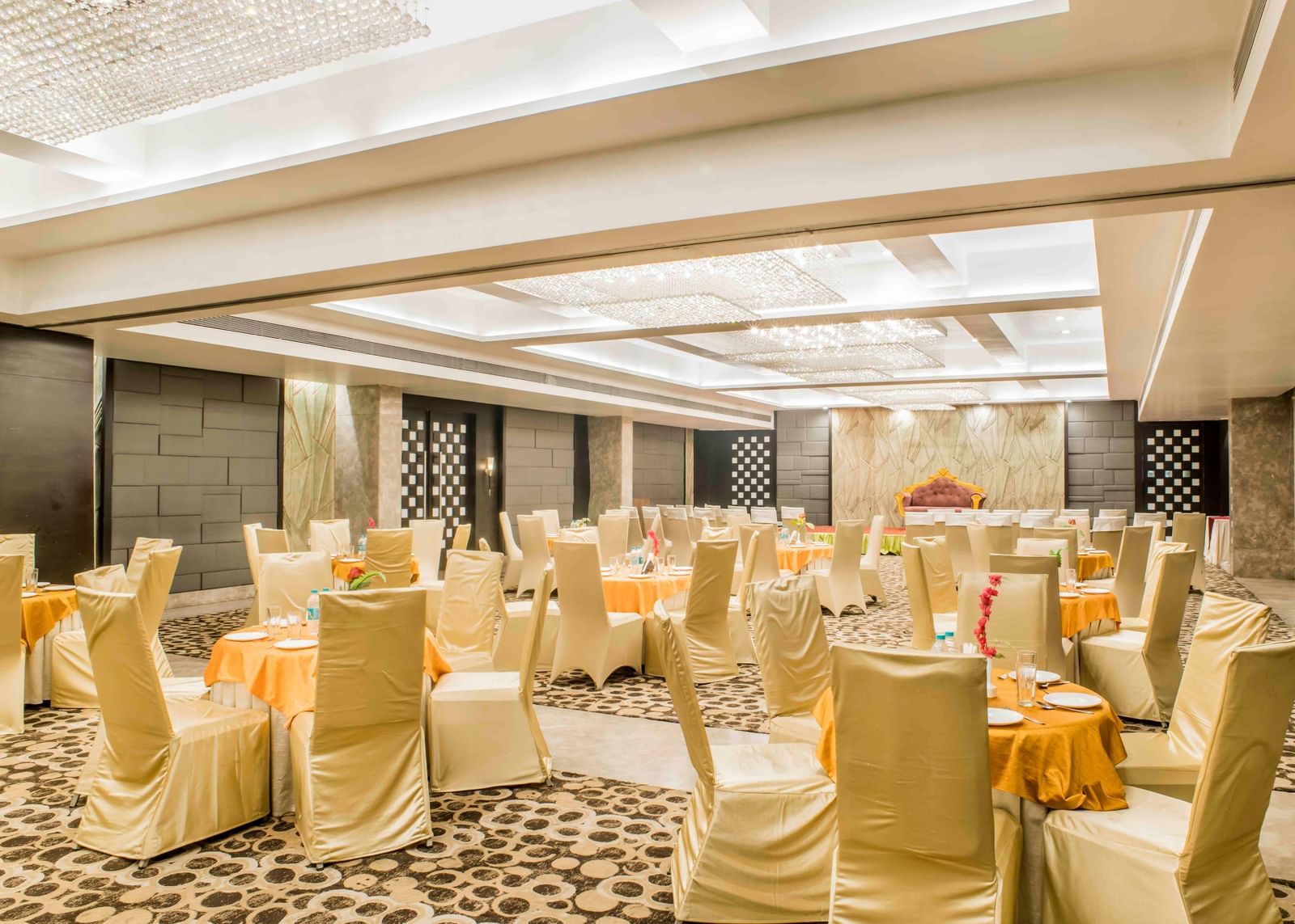 An expansive banquet hall prepared for an event with round tables and chairs at The Citi Residenci Hotel, Durgapur.