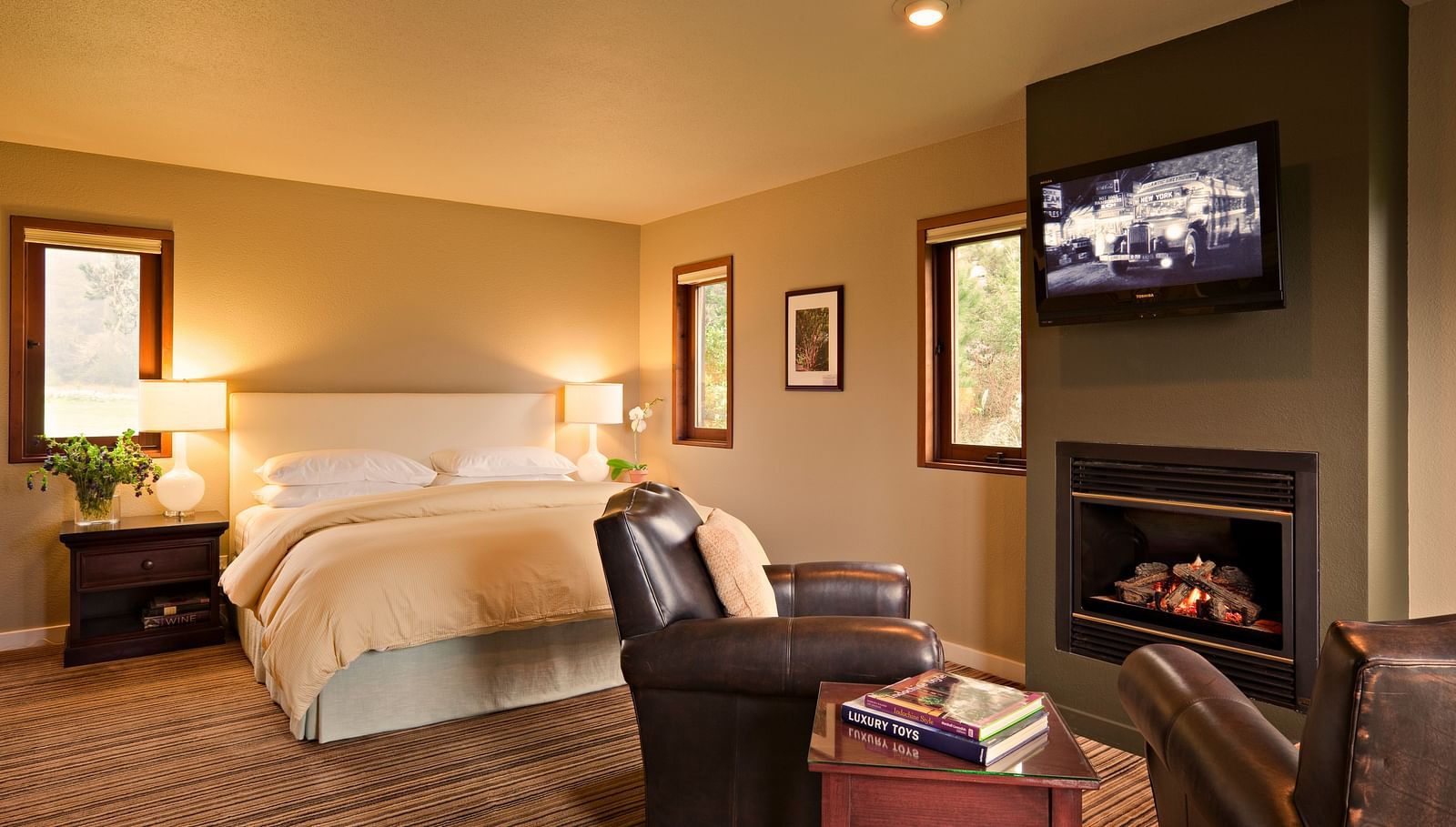 A hotel room with a fireplace, king bed, and rustic charm - Brewery Gulch Inn & Spa