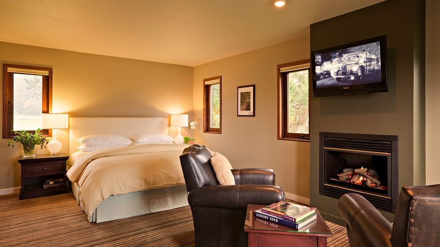 A hotel room with a fireplace, king bed, and rustic charm - Brewery Gulch Inn & Spa