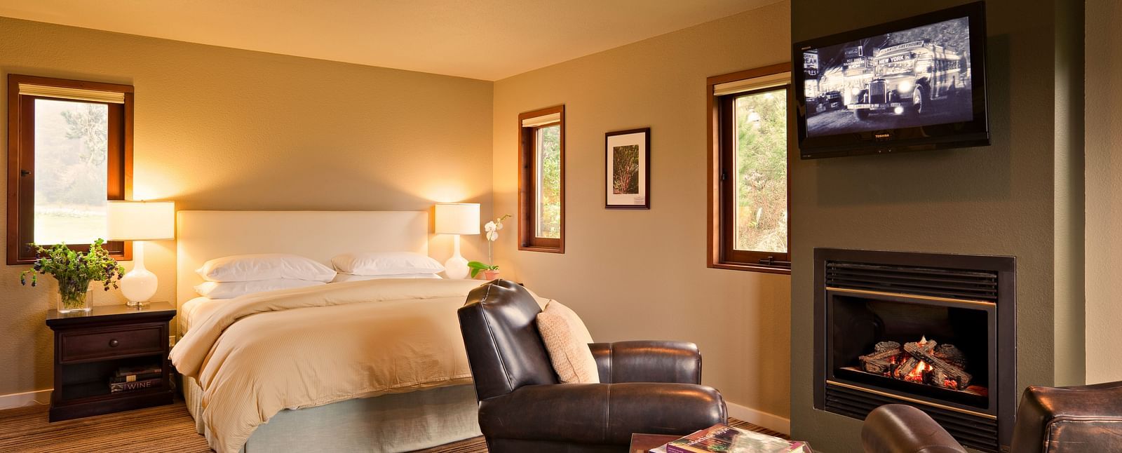 A hotel room with a fireplace, king bed, and rustic charm - Brewery Gulch Inn & Spa