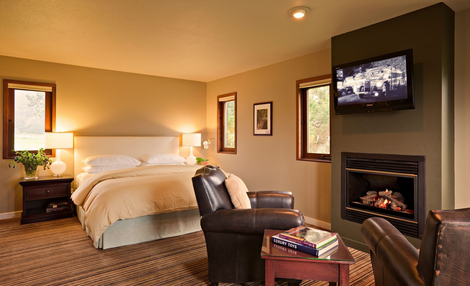 A hotel room with a fireplace, king bed, and rustic charm - Brewery Gulch Inn & Spa