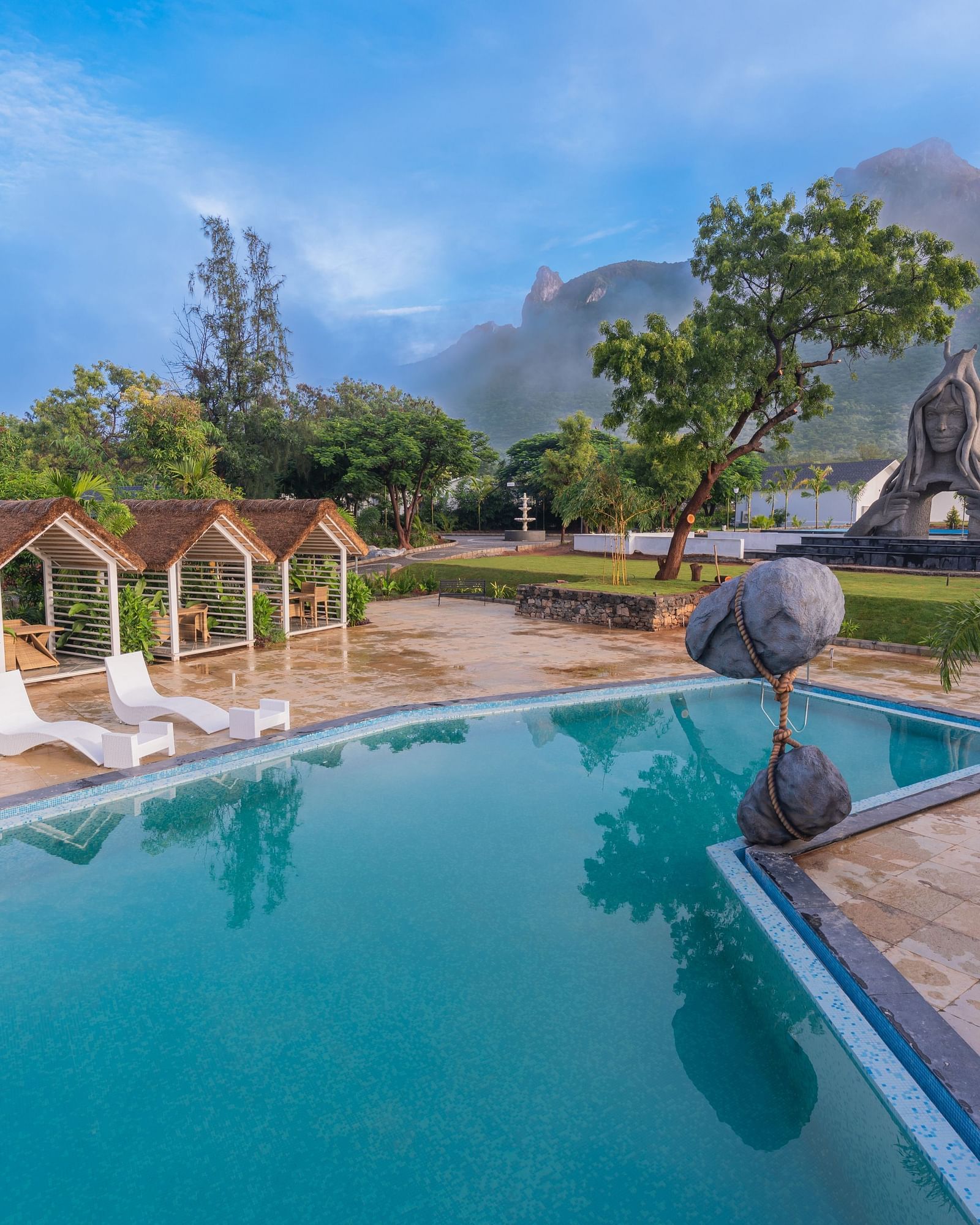 full view image of the swimming pool with three sun loungers at the poolside - Darza Resorts