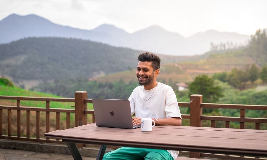 a man using his laptop and smiling