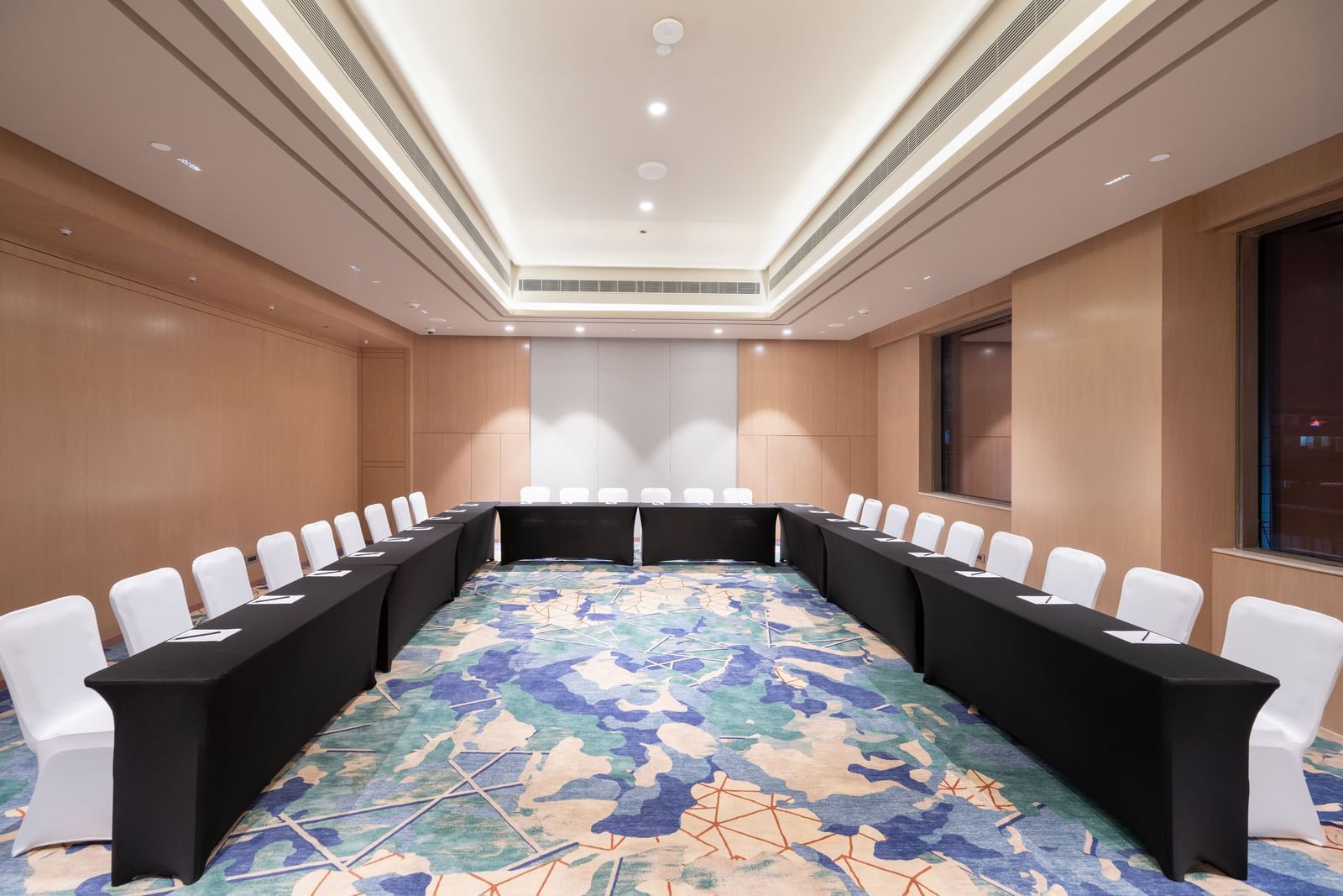 Elegant meeting space with U-shaped seating and warm lighting at Merlis Hotel, Coimbatore.