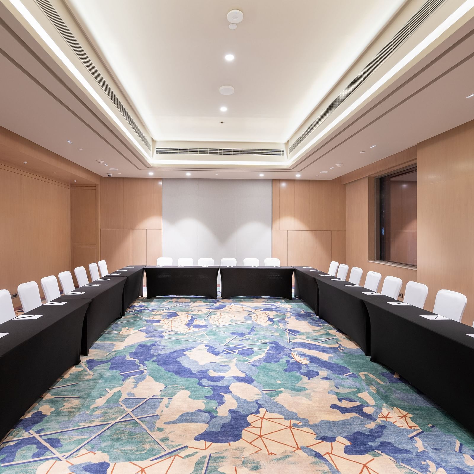 Elegant meeting space with U-shaped seating and warm lighting at Merlis Hotel, Coimbatore.