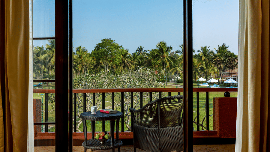 view of the balcony with chairs and a table on it inside Garden View Room - Caravela Beach Resort Goa 