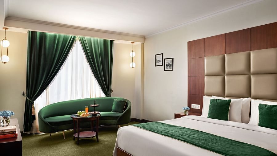 An image of the club room with a large sofa placed beside the bed - Deventure Sarovar Portico, Patel Nagar