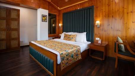 Suite at Summit North Star, Gangtok featuring a bed, a bedside table and a chair.