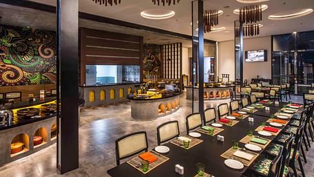 Image of the restaurant with a buffet setting.| Great Trails Wayanad by  GRT hotels. 