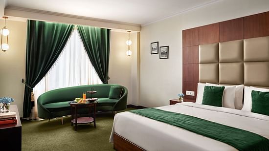 An image of the club room with a large sofa placed beside the bed - Deventure Sarovar Portico, Patel Nagar